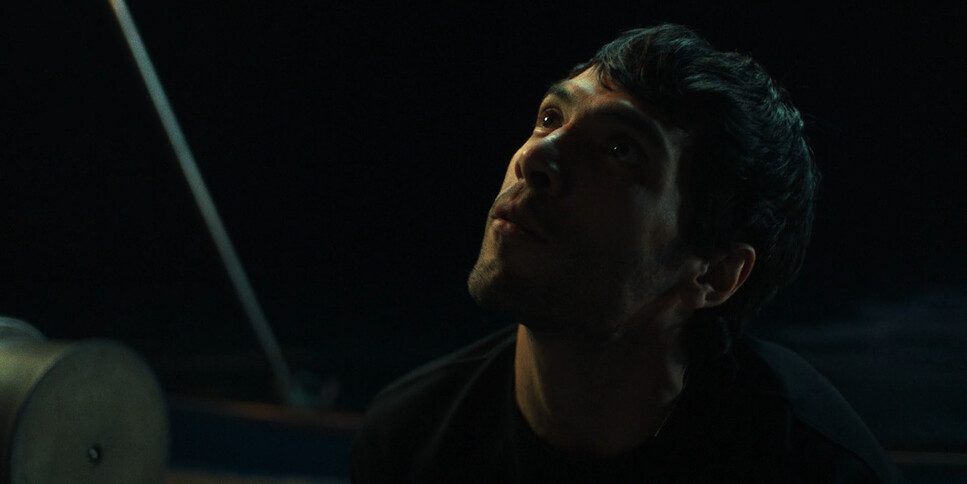 Nocturnus mood image — man on a boat at night, looking upward into the dark