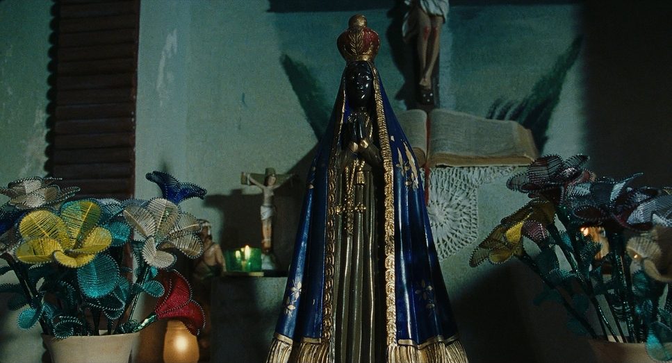 Sagrados mood image — home altar with a blue-robed Virgin statue and beaded flowers